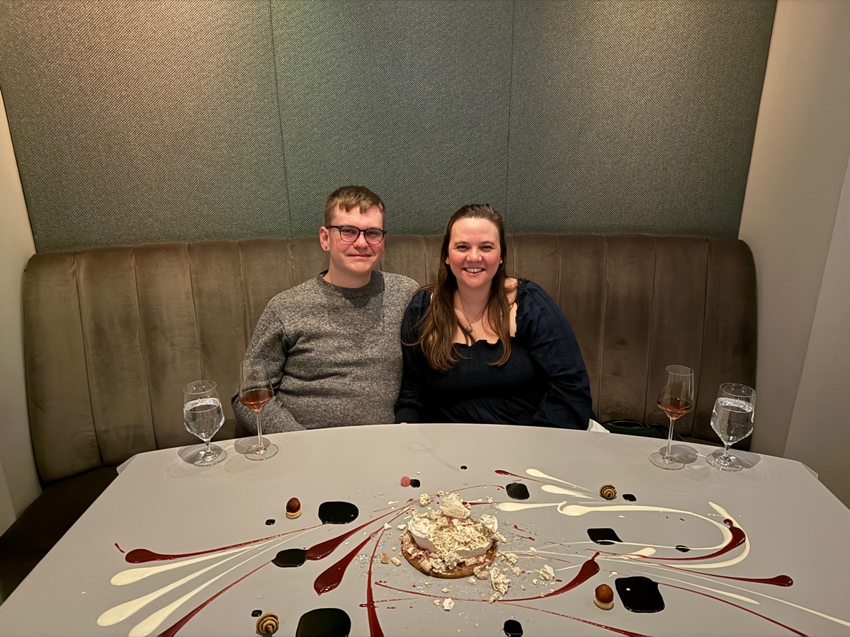 Andrew Kunesh and his wife smiling together at a restaurant in Chicago