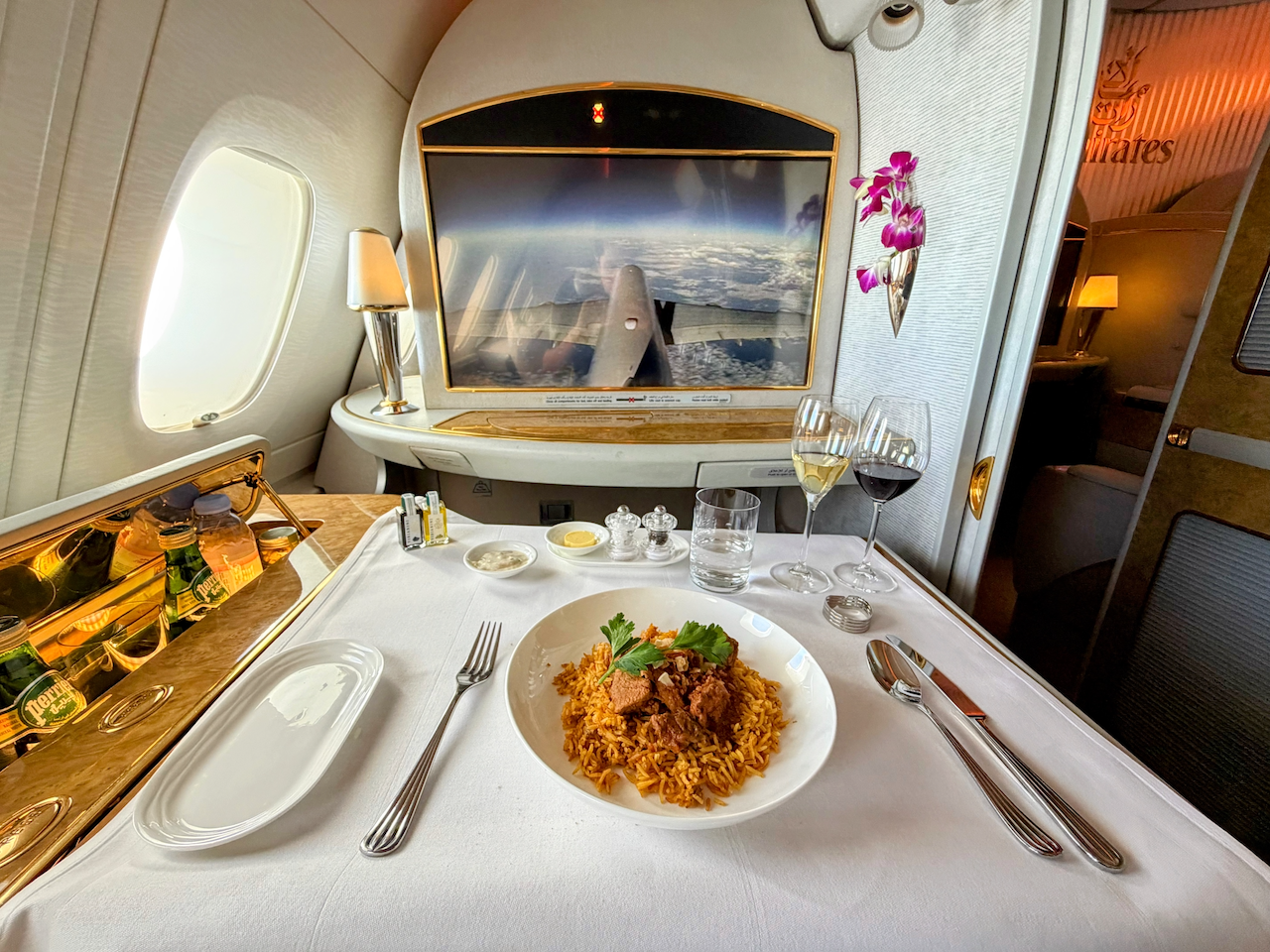 Emirates First Class suite with a meal served at the seat